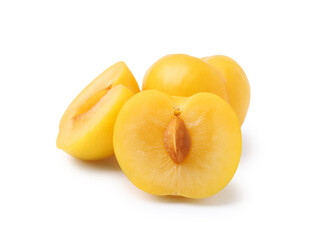 Whole and cut yellow cherry plums isolated on white