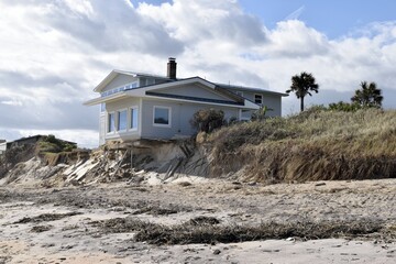 Home damage from a hurrican with beach erosion.