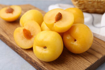 Ripe yellow cherry plums on grey table, closeup