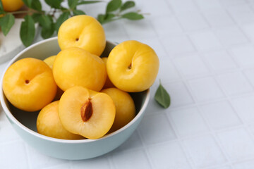 Ripe yellow cherry plums on white tiled table, closeup. Space for text