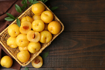 Ripe yellow cherry plums on wooden table, flat lay. Space for text