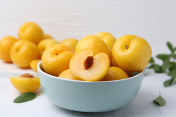 Ripe yellow cherry plums on white tiled table, closeup