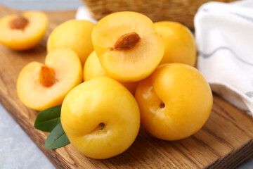 Ripe yellow cherry plums on grey table, closeup