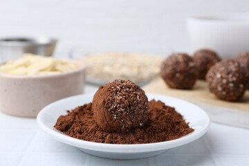 Making homemade candies. Chocolate balls and ingredients on white tiled table, closeup