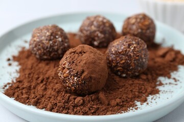 Delicious homemade candies with cocoa powder on table, closeup