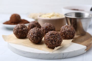 Making homemade candies. Chocolate balls and ingredients on white table, closeup