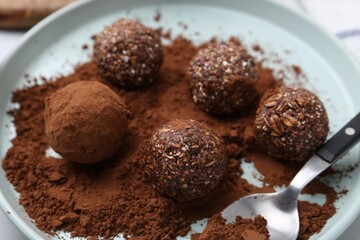 Delicious homemade candies with cocoa powder on table, closeup