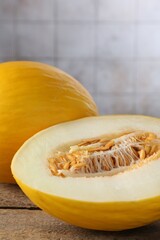 Cut and whole ripe melons on wooden table, closeup