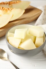 Cut ripe melon on white wooden table, closeup
