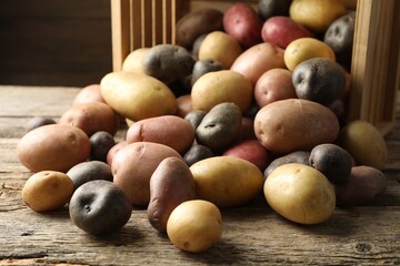 Different types of potatoes on wooden table, closeup