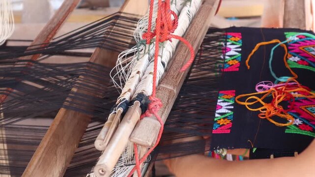 Close up footage Women weaving silk in a weaving village of Thailand.
