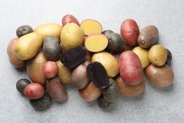 Different types of potatoes on grey table, flat lay