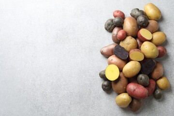 Different types of potatoes on grey table, flat lay. Space for text