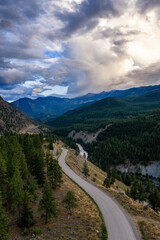 Winding Mountain Road and Forested Valleys Below Dramatic Cloudy Skies in BC, Canada