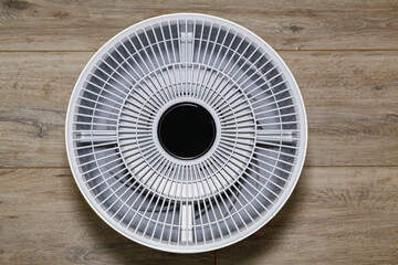 top view of a modern air purifier with circular display and radial grille design. The geometric...