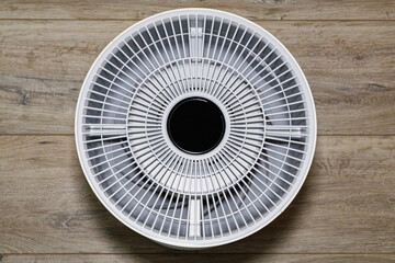 top view of a modern air purifier with circular display and radial grille design. The geometric...