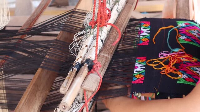 Close up footage Women weaving silk in a weaving village of Thailand.
