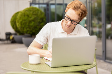 Caucasian freelancer reading schedule preparing plan writing notes switching to laptop