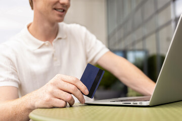 Unrecognizable businessman making purchase using laptop filling out checkout