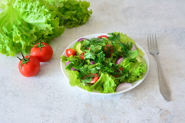 Fresh and Healthy Salad on a White Plate with Tomatoes and Lettuce and a fork