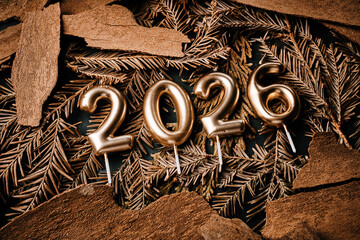 Golden 2026 Candles Resting on Rustic Wood and Greenery for Celebration