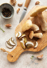 Chef preparing fresh mushrooms with garlic and pepper on cutting board