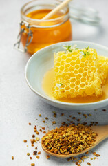 Honey, honeycomb and bee pollen creating delicious golden composition