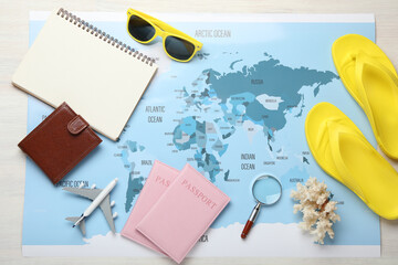 Time for summer vacation. World map, toy plane, passports, purse, magnifying glass, notebook and...