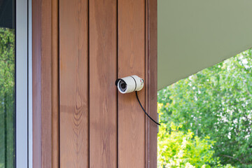 Security camera mounted on wooden siding of a building exterior