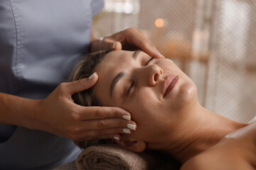 Beautiful woman receiving facial massage in spa salon, closeup