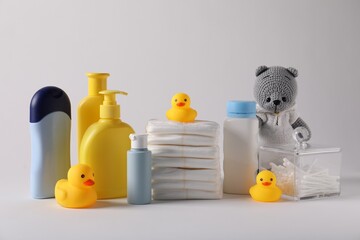 Baby accessories and body care products on light grey background