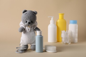 Baby accessories and body care products on beige background