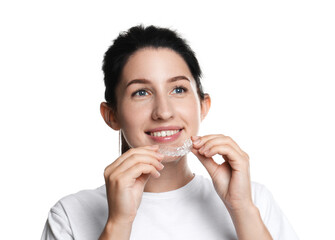 Smiling woman wearing dental aligner on white background