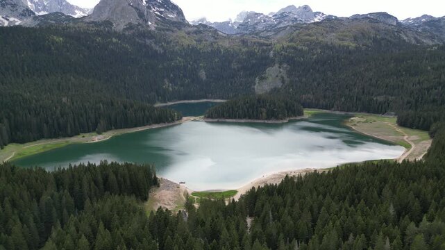 4K aerial drone footage approaching Crno Jezero Black Lake Montenegro from above with Durmitor mountains in background