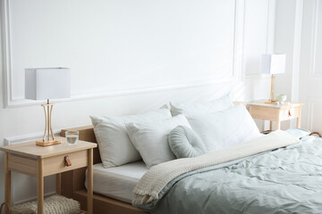 Bedside tables with lamps near bed indoors