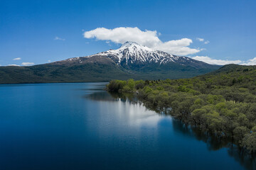 Obraz premium Scenic Aerial View of a Snow Capped Mountain Beside a Tranquil Lake