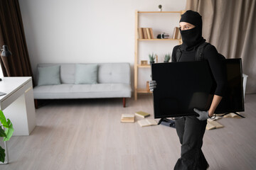 Female Burglar thief stealing tv from apartment. Criminal, house crime and breaking. robbery and...
