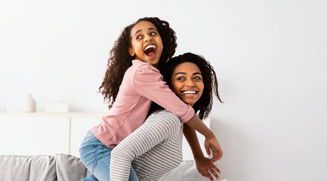 Happy Loving Family. Cheerful African American man and woman having fun with children in living room, giving smiling boy and girl piggyback ride. Four positive black people spending time together - Powered by Adobe