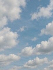 Obraz premium Blue sky with fluffy white clouds, peaceful natural background symbolizing freedom and freshness