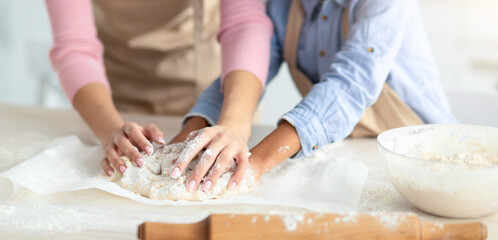 Fototapeta premium Portrait Of African American Mother And Her Little Daughter Baking Pastry In Kitchen Together, Kneading Dough On Table While Preparing Cookies, Biscuits Or Pizza, Enjoying Cooking Homemade Food