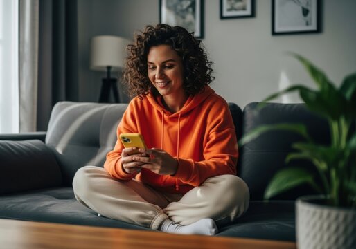 Young woman relaxing on sofa using mobile phone