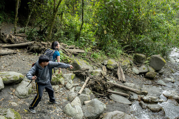 Friends playing on the shallow mountain river. Friends throwing stones