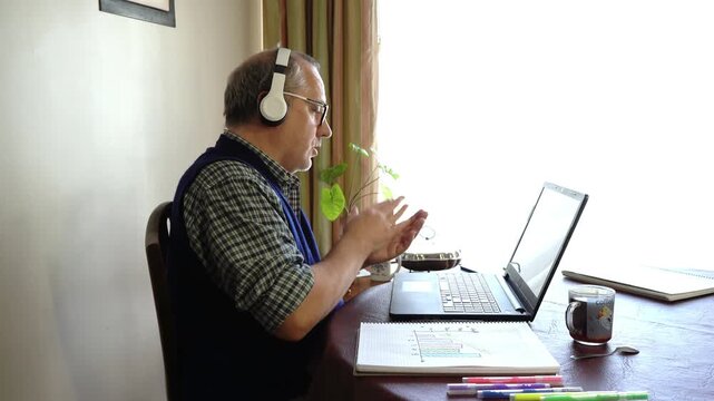 Professor using laptop for online class and showing charts