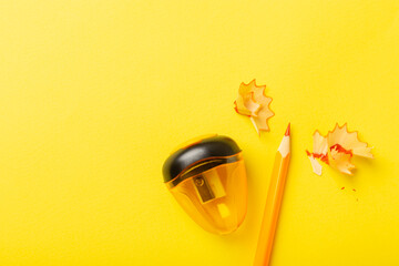 Fototapeta premium Pencil sharpener on bright colored background. Pencil and pencil shavings. Stationery. School supplies. School products. Flat lay. Place for text. copy space.