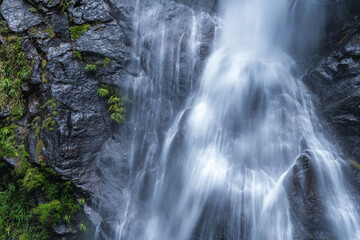 Beautiful waterfall in a tropical rainforest in a magical environment. Silk effect water in long...