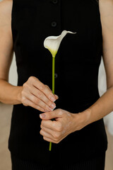 A young woman with beautiful hair gracefully poses with a calla lily 