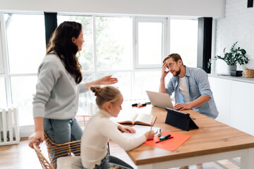 Mother leans over daughter studying beside tablet and markers, blending tech‑driven remote learning support with parent involvement and digital parenting at home.