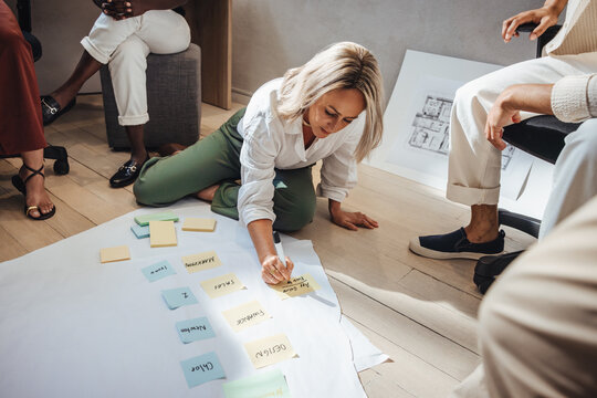 Female architect sharing ideas during team brainstorming session at creative studio.