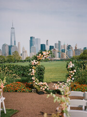 Fototapeta premium Beautiful outdoor wedding ceremony setup with skyline view in a park on a sunny day