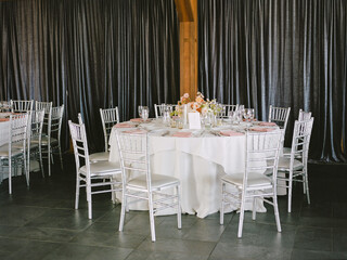 Elegant round dining table set for a formal event in an upscale indoor venue with soft lighting